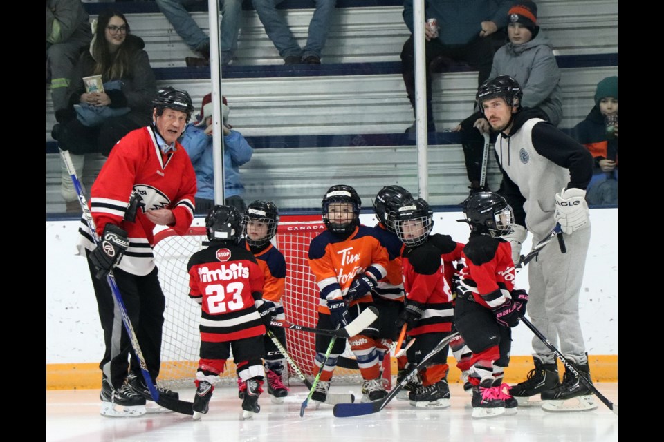 Innisfail Tim Hortons Eaglets coach Bernie Vanderham  (left) with a parent volunteer gather their young players before the start of their scrimmage on Jan. 3 before a packed house of 1,000 hockey fans at the Innisfail Twin Arena during the first intermission of the 3rd annual Battle of the Badges charity hockey game. Johnnie Bachusky/MVP Staff