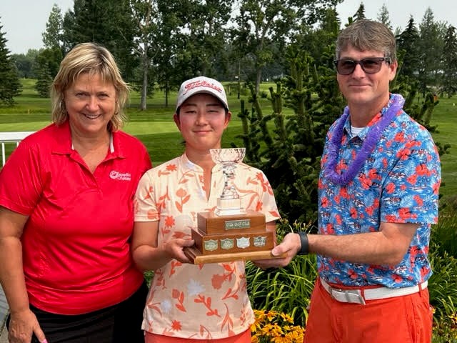 Olds Golf Club pro and manager Randy Brown, right, hands the trophy to Jin Yeo of Calgary after she won the 2023 Expedia Cruises Ladies Open golf tournament at the Olds Golf Club on July 15. At left is Susan Walker of Expedia Cruises.