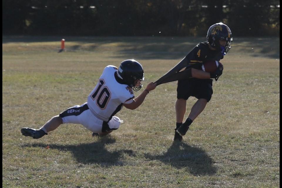 When he can’t tackle him, Darious Holland-Sowerby of the Drumheller Titans pulls on the jersey of École Olds High School Spartan Radek Heppner during their game Oct. 10 in Olds.
Doug Collie/MVP Staff