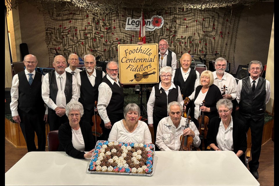 Members of the Foothills Centennial Fiddlers pose for a group photo around a table with birthday cupcakes on Jan. 16 at the Innisfail Royal Canadian Legion Branch #104 to celebrate their 20th anniversary of entertaining across the region. Johnnie Bachusky/MVP Staff