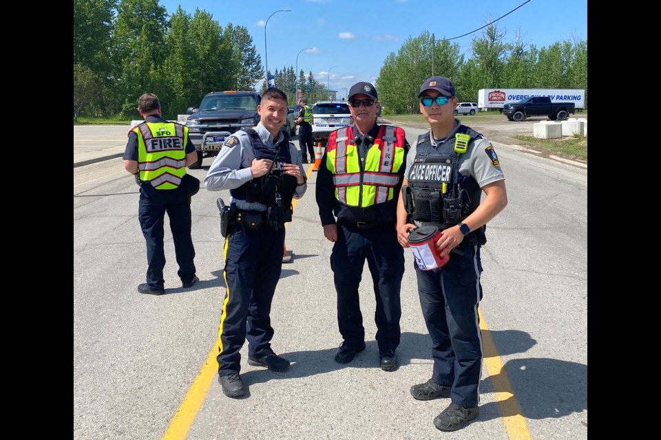 From left: Const. Nick Hull, Sundre Fire Department Chief Ross Clews, and Town of Sundre community peace officer Sam Zhao were among the numerous hands on deck assisting Greenwood Neighbourhood Place Society volunteers and board members on Friday, June 2 for the non-profit community service organization’s annual Charity Check Stop fundraising drive along the Highway 27-Main Avenue corridor in front of the local Freson Bros.
Submitted photo