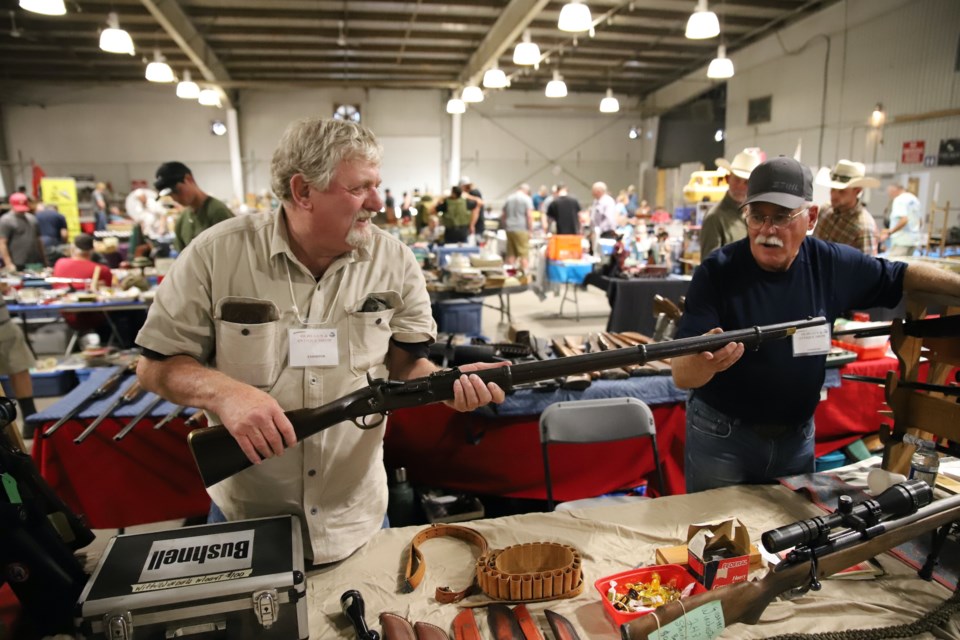 Al Simms, left, and Bill Main of Eagle Hill, northwest of Olds, show off a Snider-Enfield, dating back to 1864. Simms and Main had one of more than 250 booths during the 10th annual Olds & District Gun & Antique Show, held Aug. 10-11 at the Cow Palace. 
Doug Collie/MVP Staff