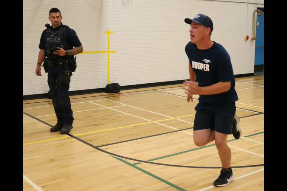 Cst. Mitch Price watches as Owen Hooper, one of the academy participants, runs as part of an excerise that also involved picking up and carrying two heavy weights.
Doug Collie/MVP Staff