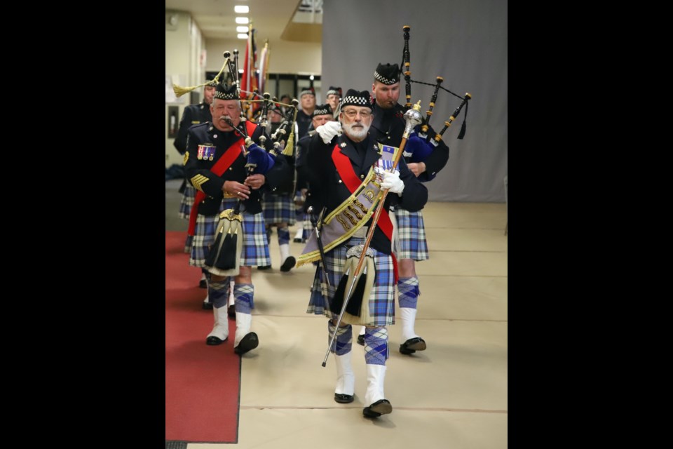 Members of the Alberta Justice and Solictor General Regimental Pipes & Drums lead the colour party as the Olds Remembrance Day service begins.