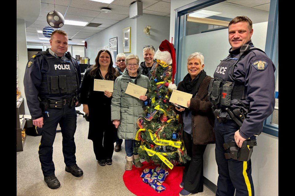 Representatives from three non-profits were at the Innisfail RCMP detachment on Dec. 10 to each receive a cheque for $5,501.88. It was money raised from the 28th annual Innisfail RCMP Charity Check Stop on Dec. 7. From left to right is detachment commander Staff Sgt. Ian Ihme, Carrie Bottomley, community development officer at the Central Alberta Child Advocacy Centre; Diana Cooper, Heather Taylor and Val Davies from the Innisfail and District Food Bank; Lynn Holinski, chair of the Innisfail Christmas Bureau, and Innisfail RCMP Const. Craig Nelson.  Johnnie Bachusky/MVP Staff