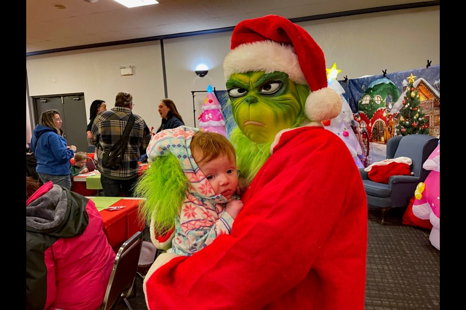 The Grinch's heart is warmed through a snuggle from three-month-old Lily Audet-Dulac who came to the 4th Annual Innisfail Grinchmas with mom Charla and three-year-old sister Rylee. Johnnie Bachusky/MVP Staff