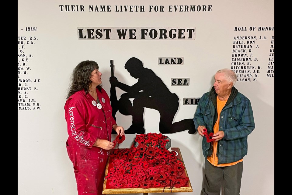 Innisfail artist Karen Scarlett and Ron King, an executive member of the Innisfail Royal Canadian Legion Branch #104, check out a  table full of 1,000 crochet poppies created for a special commemorative curtain that will be hung to honour this year's veterans for Remembrance Day. Johnnie Bachusky/MVP Staff