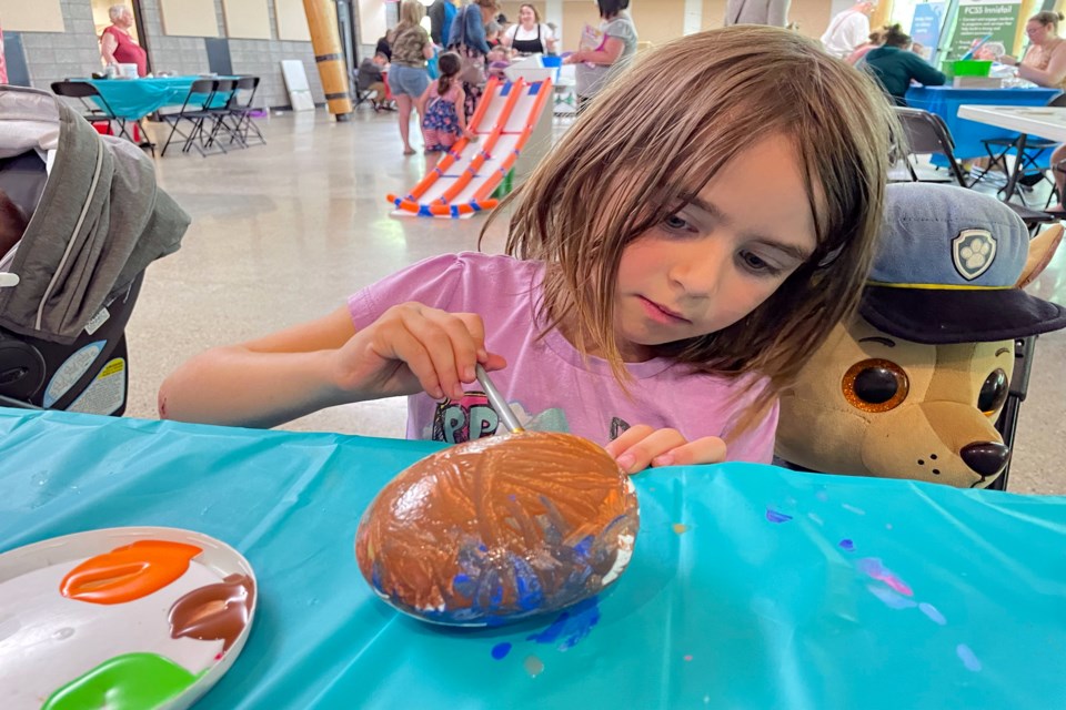 Innisfail's five-year-old Cali Riches works hard on June 4 to get the right artistic touch at the rock painting table at the Community Carnival celebration at the Innisfail Library/Learning Centre. The carnival, which had several activities for children and a free barbecue, was held to recognize the library and learning centre's milestone 10th anniversary. 
Johnnie Bachusky/MVP Staff