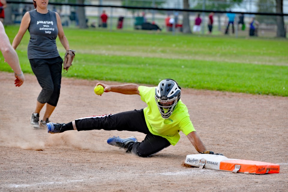 Bambino pitcher Bruce Sanford dives to get the out during sudden death playoff action on Sunday, Aug. 21. as teammate Tiffany Pembleton looks on. Patrick Teskey Photography