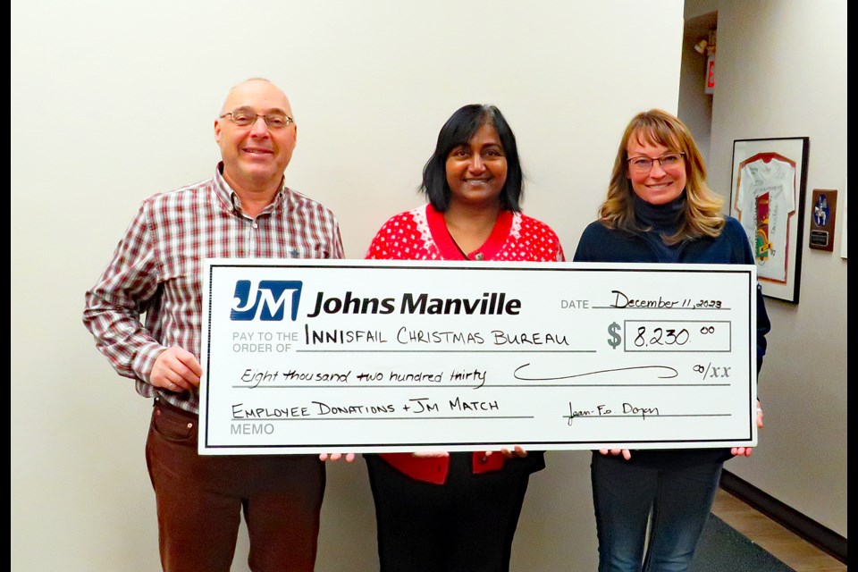 Sue Haddow, donations coordinator for the Innisfail Christmas Bureau, centre, receives a donation of $8,230 from Jean Francois Doyon, plant manager at Johns Manville and Heather Cooper, a company senior human resources generalist, during the Christmas holidays to help the bureau complete its mission in 2023 to support the community's less fortunate. Submitted photo