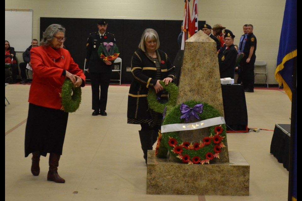 Olds Mayor Judy Dahl, left, and Mountain View County Coun. Jennifer Lutz lay wreaths during the Remembrance Day service in the CLC gym in Olds.