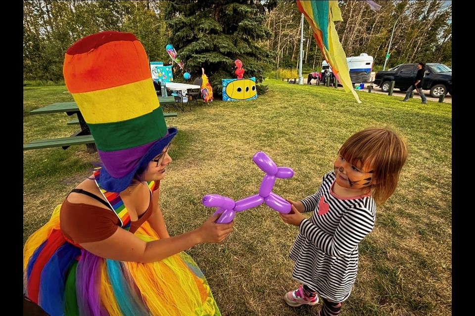 The Joyful Jester of Bowden, Azia "Zee" Jamesson, creates a special balloon for a grateful young attendee at the 3rd Annual Innisfail Lantern & Light Festival at Centennial Park on Aug. 24. Johnnie Bachusky/MVP Staff