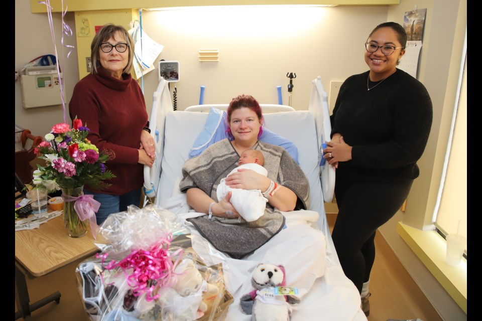 Representatives of the Olds Healthcare Fundraising Committee,: vice-chair Sylvia Harder, left, and admin coordinator Jinell Dupuis, right pose with gifts brought for the Olds hospital's New Year's baby Lydia Star Jane Myre and her mom, Tanis, centre.
Doug Collie/MVP Staff