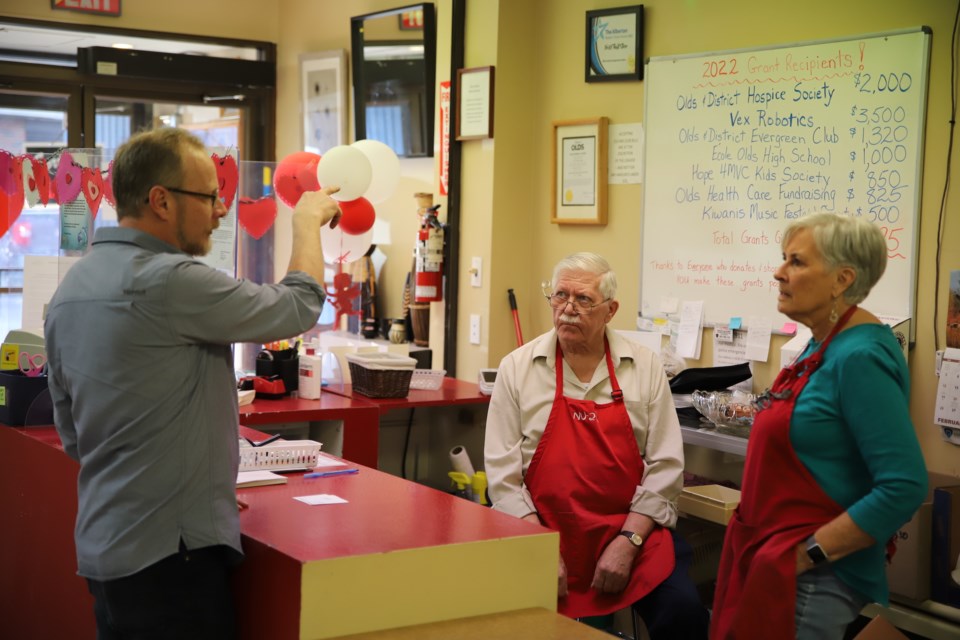 Jonathan Smith, the newly-hired manager of the Nu2U Thrift Store, discusses store operations with a couple of volunteers.