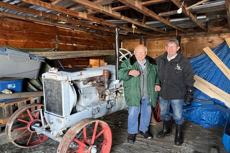 Ken Halverson (right) and Lawrence Gould, project manager at the Innisfail and District Historical Village, by the Wallis tractor model 12-20 during his visit with Coun. Jason Heistad to Hanna last month. Submitted photo