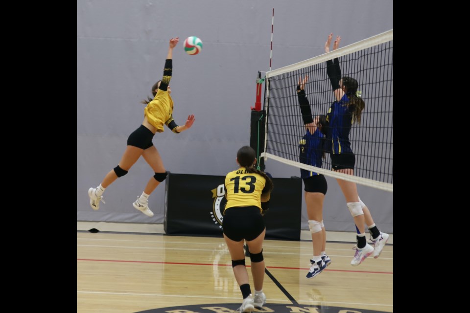 Hannah Zurkan attempts a spike as teammate Rowan Lansign (13) looks on during the École Olds High School home tournament.
Doug Collie/MVP Staff