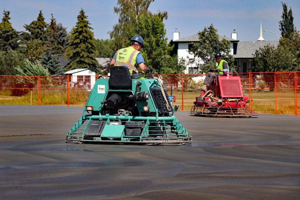 Workers from Reward Construction Ltd. perform preparatory work on the concrete surface of the new outdoor rink before it's cured for seven days. Johnnie Bachusky/MVP Staff