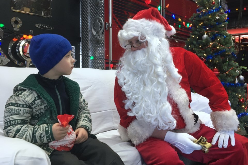 The Sundre Fire Department hosted Santa on Saturday, Dec. 14 at the hall, where there was plenty of popcorn, candy canes, hot chocolate and kid-sized fire helmets in an assortment of colours for children to choose from. Among them were five-year-old Vlad Korotchenko, who was happy to see jolly old St. Nick and came out with his mom Alyona Korotchenko, who a little more than a year ago moved to Sundre from St. Petersburg, Russia after her husband Veniamin found work in Calgary. 
Simon Ducatel/MVP Staff