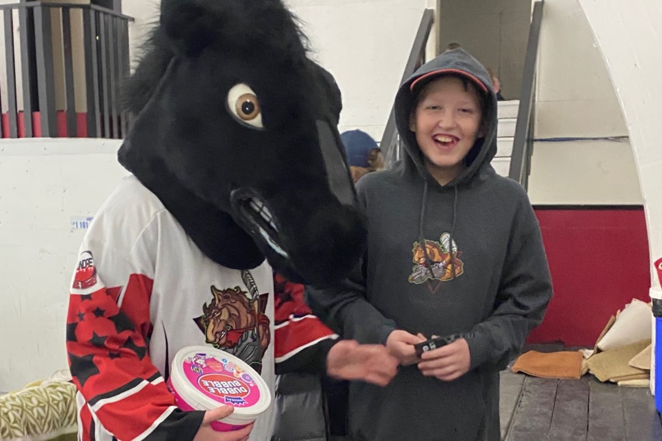 Ethan Zloty, who plays with the Sundre Rec Hockey Association’s U15s, enjoys a laugh with team mascot Spirit the Mustang during the Sundre Winter Classic that was held Jan. 31 to Feb. 2 at the local arena. Submitted photo