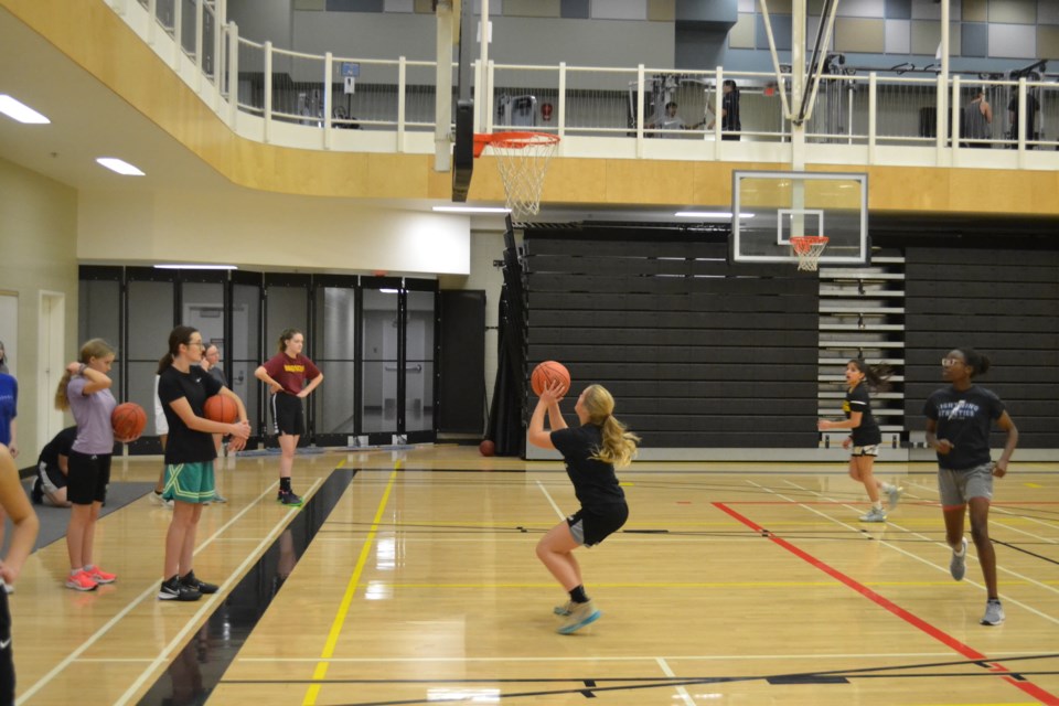 Players practise their shooting skills during tryouts for the Olds High School senior girls basketball team.