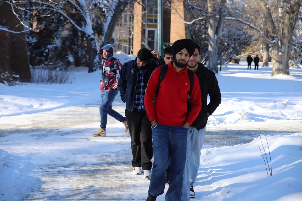 Students walk across campus amid the snow-lined trees.
Doug Collie/MVP Staff