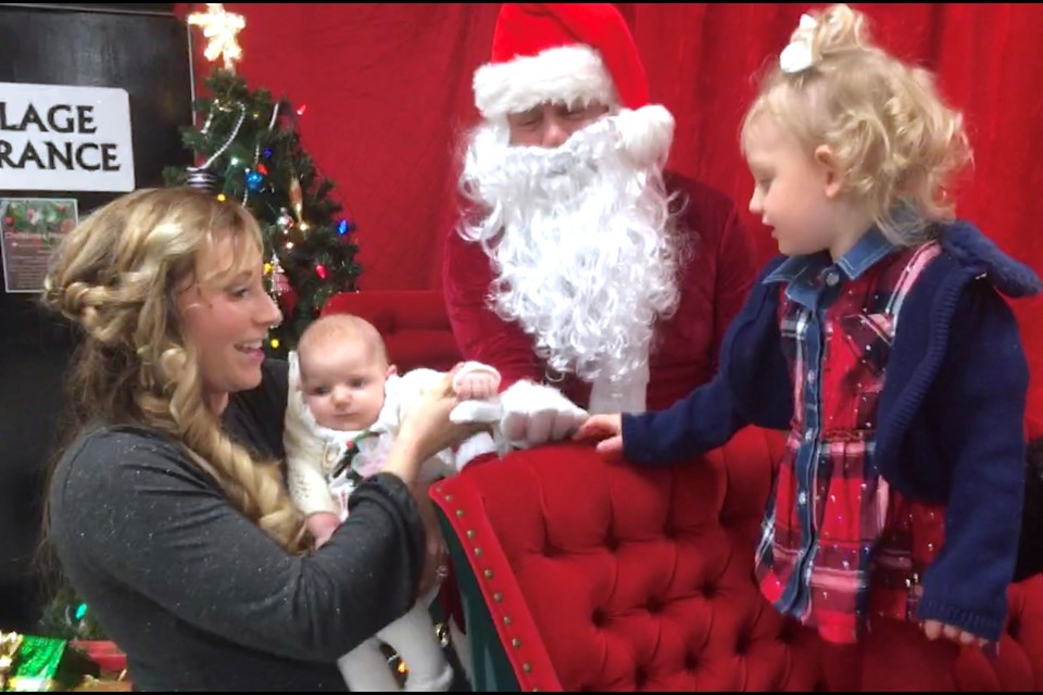 Mom Shelby Sheppard, from the Cremona area, shares a moment with children Harlynne, 2, and Elory after finishing up a family photo shoot with Santa Claus at the Sundre & District Museum on Friday during Sundown in Sundre activities. Shelby was joined by husband Dan as well as her parents Gail and Wes Cummings, who came to visit from Water Valley. 
Simon Ducatel/MVP Staff