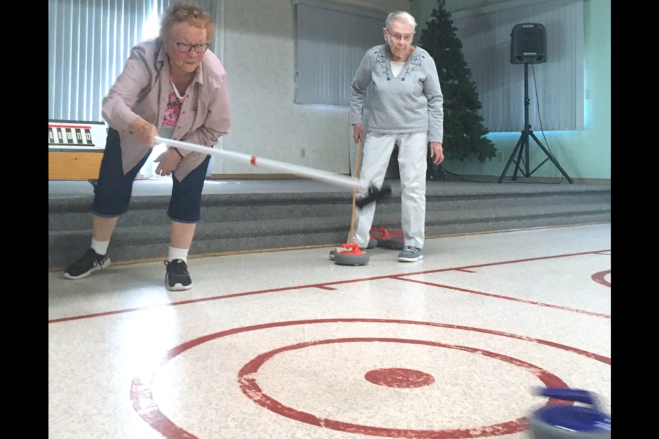 Gayle Mennear, left, releases a rock while Bobby Douglas watches the play on Friday, Aug. 9 at the Sundre West Country Centre during a weekly gathering to enjoy some fun, informal floor curling.
Simon Ducatel/MVP Staff