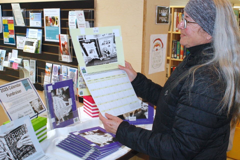 Lyn Hellmer, a new Sundre Municipal Library board member, picks up one of only 100 limited-print special edition 2025 calendars that feature a compilation of pictures of reader-recommended titles. The Friends of the Sundre Library just this year introduced the new calendar fundraiser that features people’s favourite books that they would highly recommend coupled with a quote about what the title means to them. Simon Ducatel/MVP Staff