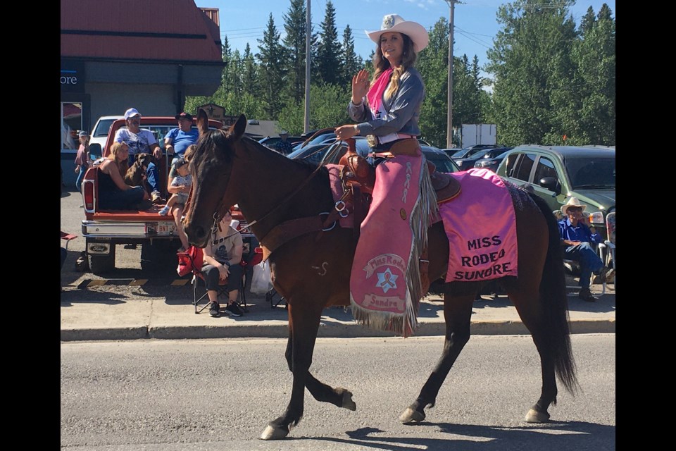 Miss Rodeo Sundre 2022-23 Jamie Davies waves to a sizeable crowd of people who lined up along both sides of the Highway 27-Main Avenue corridor through Sundre's downtown, with many others also enjoying the parade from side streets as the procession wound its way back down 4th Ave. SW to the staging area. 
Simon Ducatel/MVP Staff