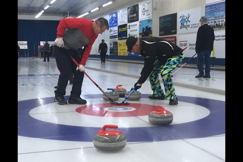 Lead Barry Panrucker, left, sweeps home a rock alongside team skip Rob Lang this past Friday afternoon during the Sundre Seniors' Bonspiel B event final, which their rink went onto win. The A event winners were the Lonnie Halladay rink, while the C event was won by Lance Dichrow's team.
Simon Ducatel/MVP Staff