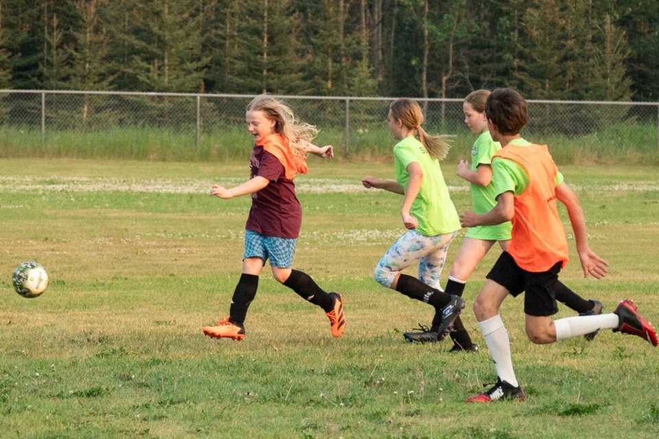 Sawyer Jones charges after the ball with other players in hot pursuit during the first-ever, post-season summer soccer academy sessions put on by the Sundre Soccer Club. Following regular season play that wrapped up earlier this summer, the club arranged to introduce the academy that brought out approximately two dozen players who didn’t pass up on the opportunity to further develop their skills. 
Photo courtesy of Kim Koop