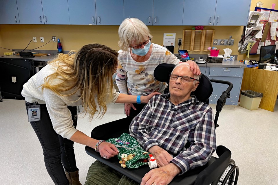 Ernest Marr, an 85-year-old resident at Rosefield Centre living with dementia, is offered a twiddle muff for sensory stimulaton by his wife Nyna (centre) and Melissa Slater, a therapy assistant. Johnnie Bachusky/MVP Staff