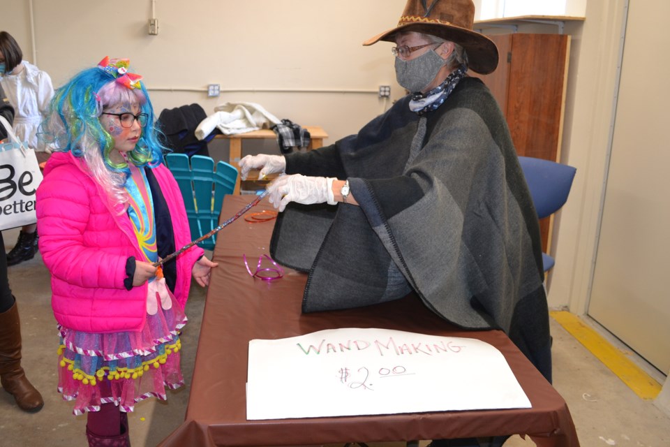 Volunteer Greta Bolton, right, applies the finishing touches to Candy Queen Kylee Bressler, 8, of Olds during a wand-making table at the Mountain View Museum on Oct. 31.
Doug Collie/MVP Staff