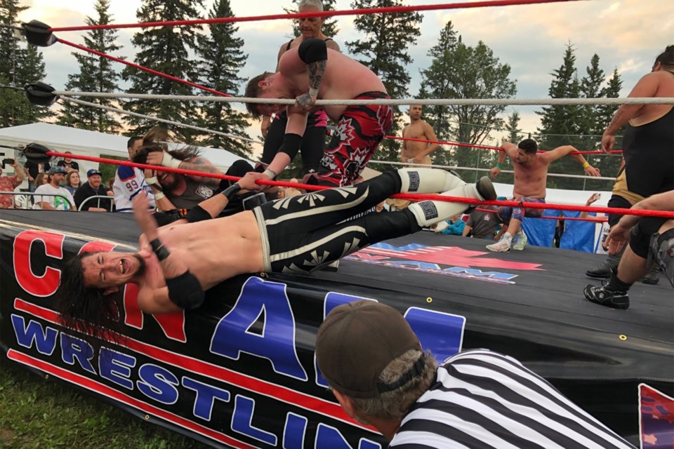 Wrestlers battle in the ring with hundreds of fans taking in the open-air action of the professional Can-Am Wrestling Resurrection at the Elkton Valley Campground on Saturday evening, July 3. 
Photo courtesy of Helen Jackson