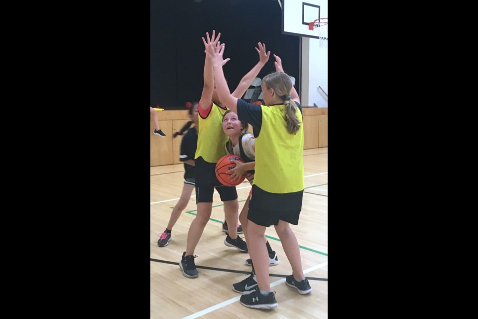 Jamay Boulton, centre, looks for a shot through a defensive double team by Reese Thiessen, right, and Yanna Magno during a two-on-two scrimmage.
Simon Ducatel/MVP Staff