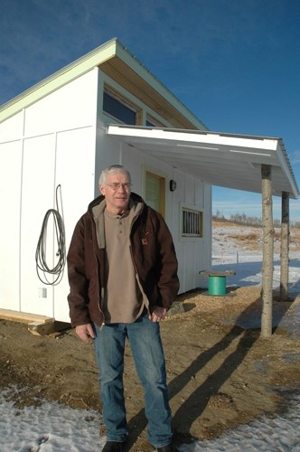 Rick Sarsons stands beside his protest cabin.