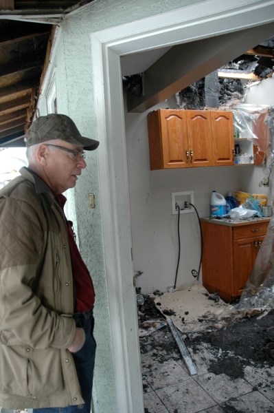 Ray Scott looks over fire damage