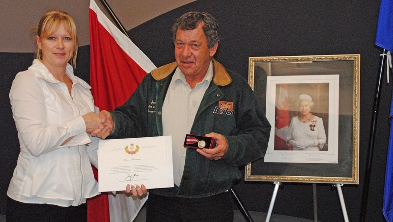 Mayor Annette Clews presents the Queen Elizabeth ll Diamond Jubilee Medal to Sundre citizen Tom Mennear at the town office on Dec. 10.