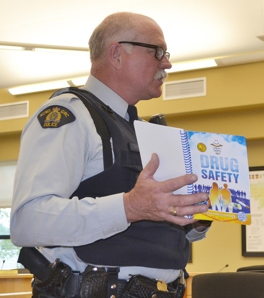 Sundre RCMP Const. Val Dennis promotes a book and video warning about the dangers of drugs during an Olds Rural Crime Watch Association meeting held at the end of May in