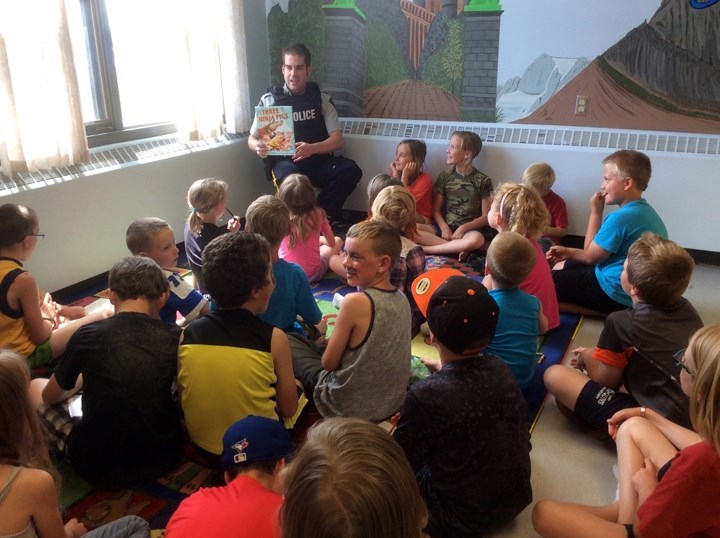 More than 40 children attended the kickoff for the Sundre Municipal Library&#8217;s Summer Reading Program on Wednesday, June 29. Pictured here is Const. Mike Martin getting