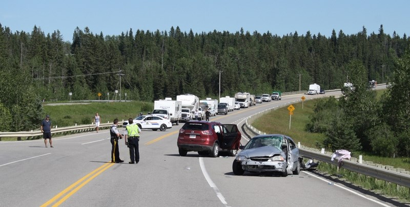 RCMP officers work at the scene of a two vehicle crash at Westward Ho on Sunday afternoon. Seven people were hurt in the mishap, which remains under investigation.,