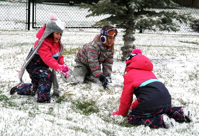 Mackenzie Smethurst, 9, centre, did not waste any time getting bundled up to go out and play in the first snowfall of the season on Friday, Oct. 7 with her friends Tori, 5,