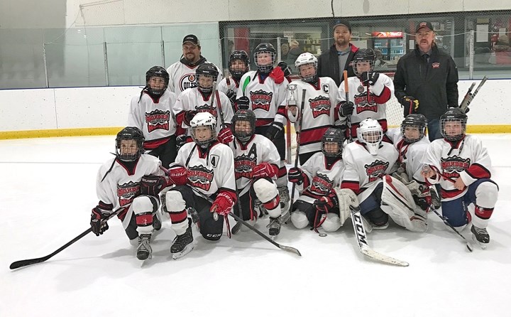 The Sundre atom Huskies pose for a group shot on Sunday, Dec. 4 after winning the D final during the team&#8217;s annual home tournament.,