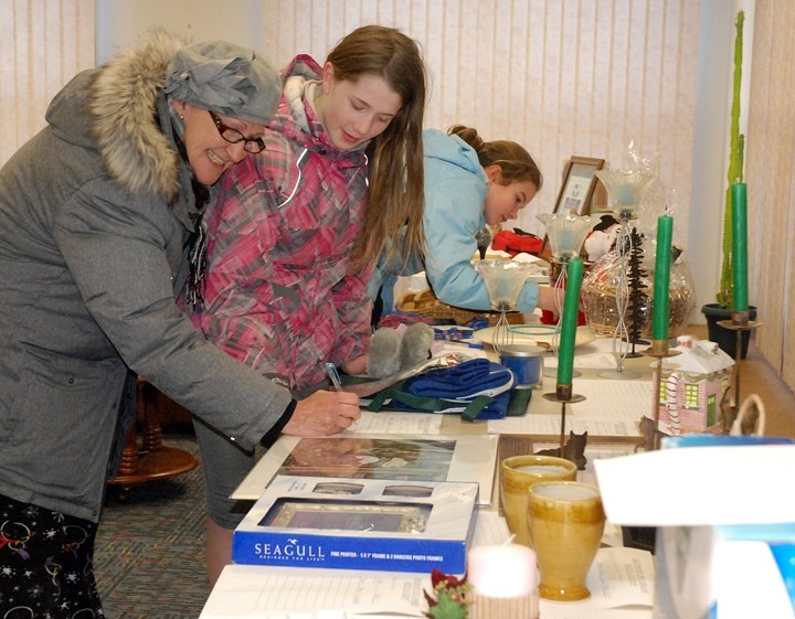 The Sundre Municipal Library&#8217;s annual silent auction fundraiser started last week and winds up this Friday, Dec. 16. Pictured here bidding on some of the numerous items 