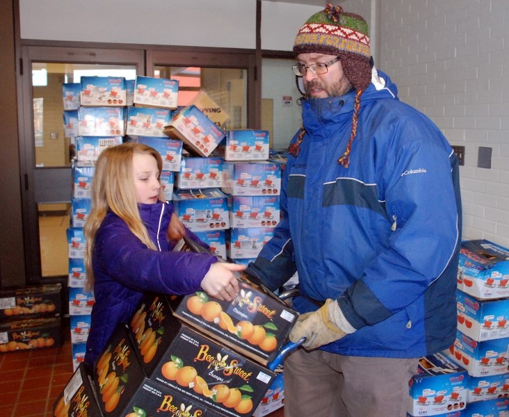 River Valley School Grade 7 teacher Mark Proctor gets some help from Grade 7 student volunteer Zoe Davidson on Tuesday, Feb. 7 to load up orders of grapefruit and oranges for 