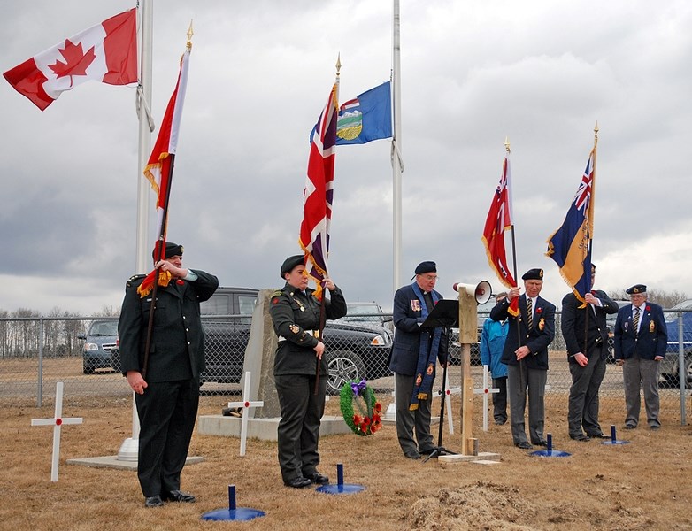 Cpl. Ethan Tetreault of the Olds Air Cadet Squadron 185 reads part of an account of the Vimy Ridge assault during the service. Standing behind him are his brother, F/Cpl.