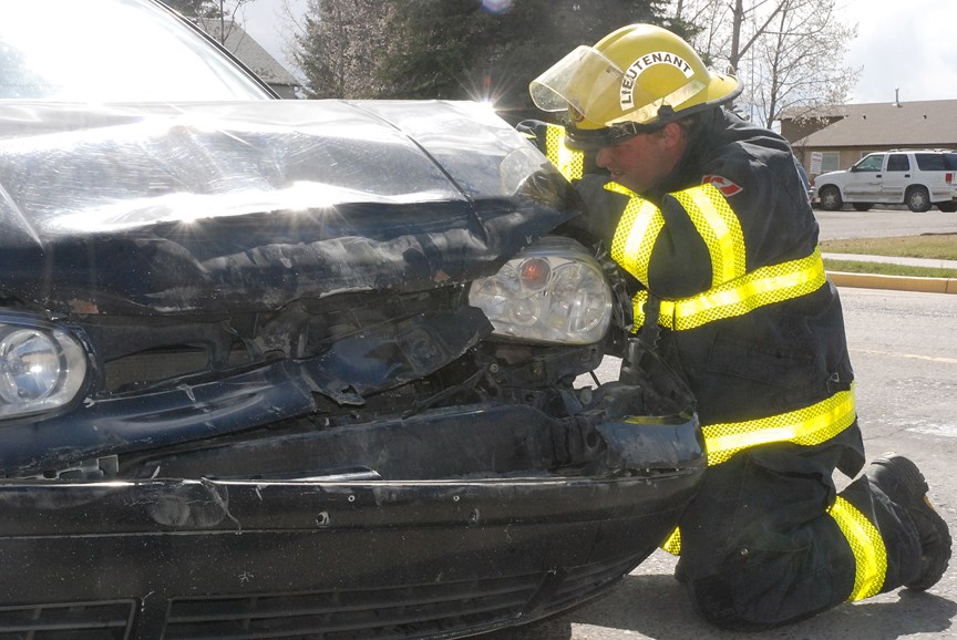 Den Hass, a lieutenant with the Sundre Fire Department, inspects a damaged vehicle that was involved in a fender-bender along Centre Street just north of River Valley School