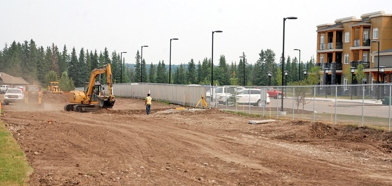 A construction crew works on a landscaping project, which includes a walking path, immediately north of the Sundre Seniors&#8217; Supportive Living centre, pictured in the