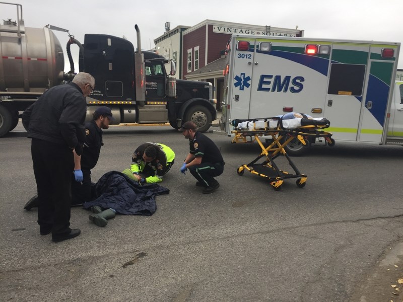 Sundre EMS personnel treat a woman struck by an SUV at the intersection of Main Avenue and 2nd Street West on Sept. 12. The woman was taken to Sundre hospital by ambulance.