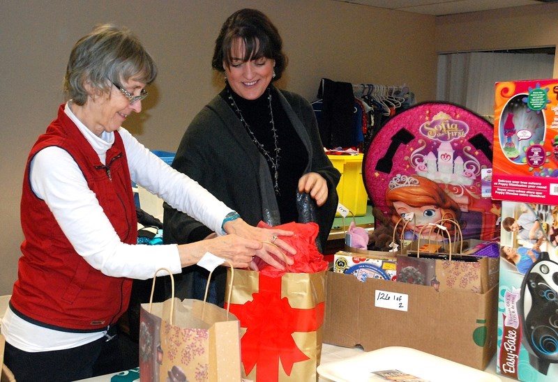 Heather Dales was among numerous Sundre Santas volunteers working hard to package and prepare holiday hampers last week. She is pictured here wrapping a gift at the workshop, 